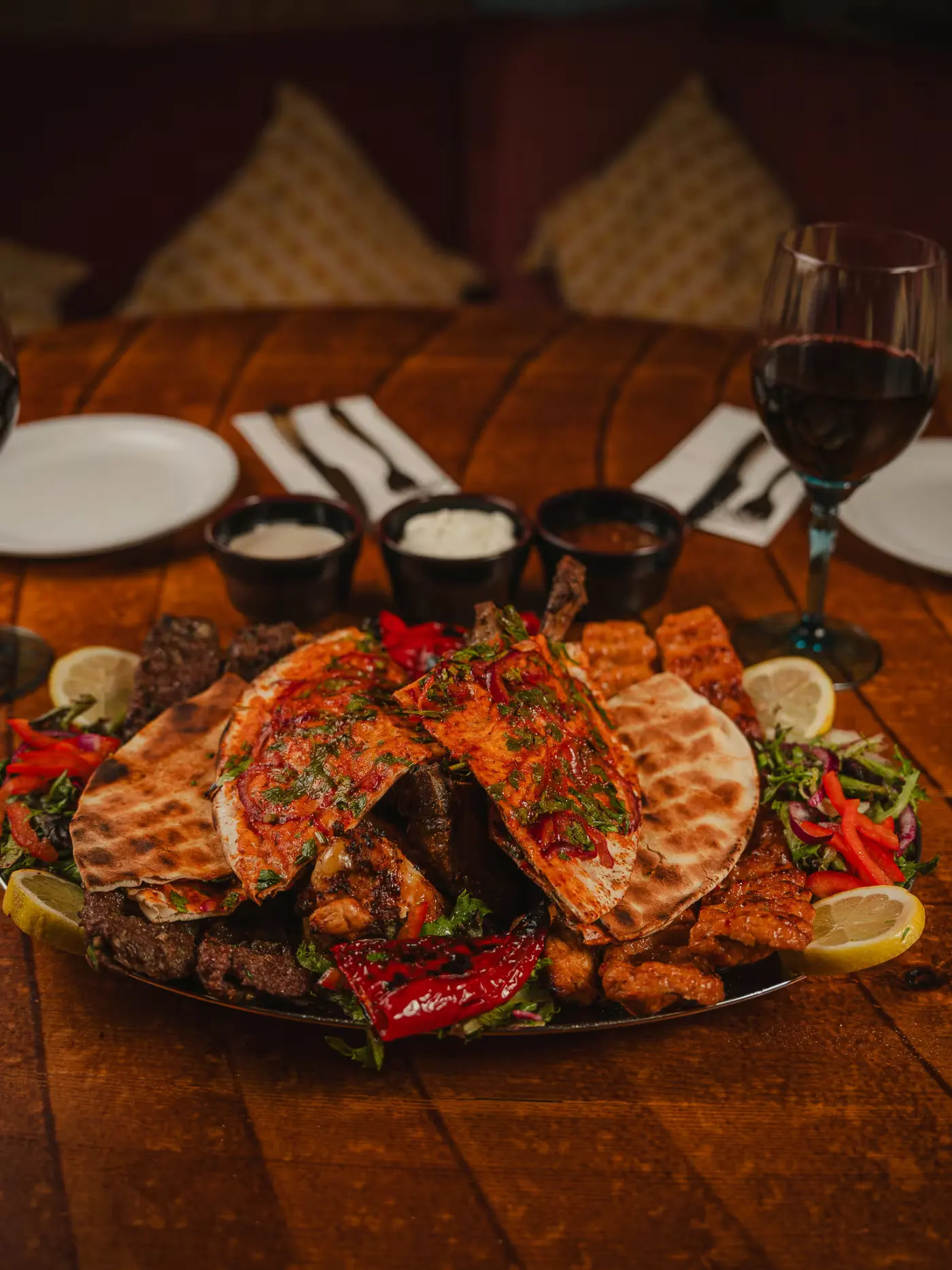 Grilled chicken platter with flatbread and wine glasses on the table at Beirut Restaurant, captured by Gorka Di Capitan (gorkadicapitan.com), food photography